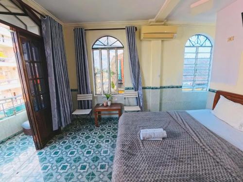 a bedroom with a bed and two windows at QUANG'S nhà nghỉ in Thôn Kim Long (1)