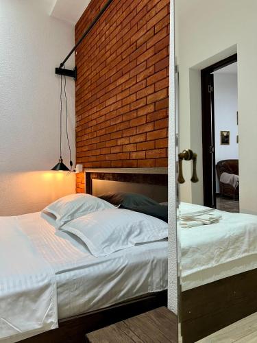 a bed in a room with a brick wall at Vernisa hotel in Tbilisi City