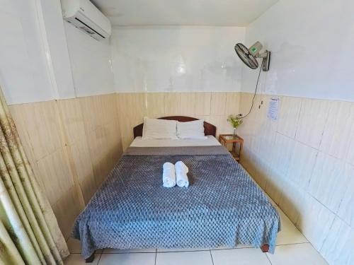 a bedroom with a bed with two white slippers on it at QUANG'S nhà nghỉ in Thôn Kim Long (1)