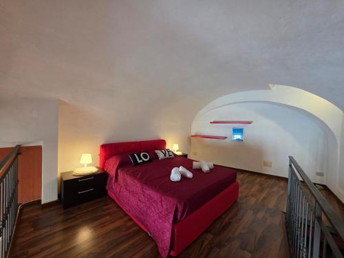 a bedroom with a red bed with two teddy bears on it at Old Town, Loft with Square View in Toirano