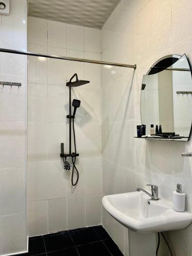 a white bathroom with a sink and a shower at Vernisa hotel in Tbilisi City