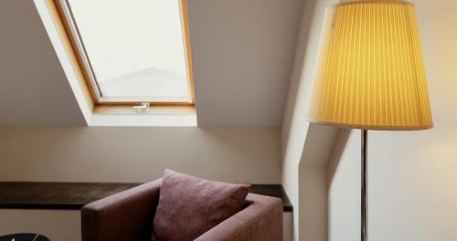 a lamp and a chair in a room with a window at Vértice Sevilla in Seville