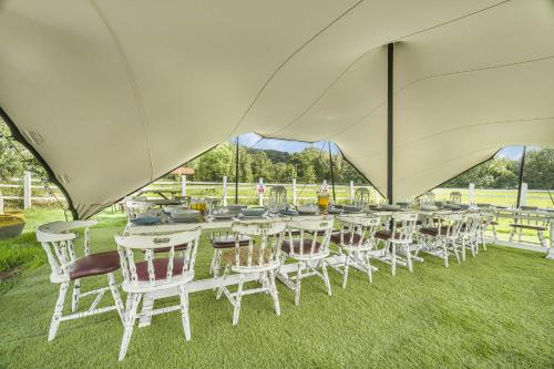 a group of tables and chairs under a large tent at Entire Venue Hire with 8 Bedroom Accommodation - Your Own Pub Experience in Swansea