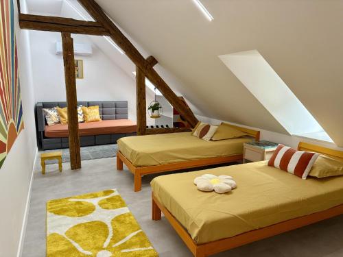 een zolderkamer met twee bedden en een bank bij Appart Saint Jo in Colmar