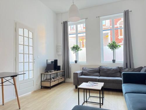 a living room with a couch and a tv at Les arts chambres 4 SDB privatif 1 er etage in Roubaix