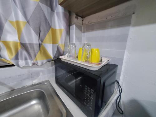 a kitchen with a sink and a microwave at Premier homes w free parking n lift in Rungiri