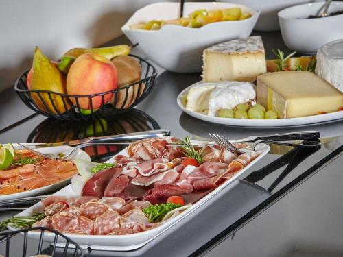a buffet of different types of food on a table at La Licorne Hotel & Spa Troyes - MGallery Collection in Troyes
