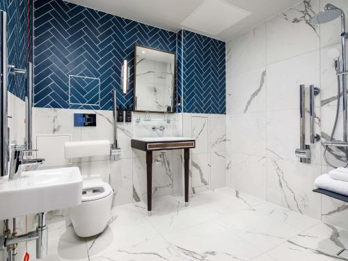 a bathroom with a sink and a toilet at The Municipal Hotel Liverpool - MGallery in Liverpool