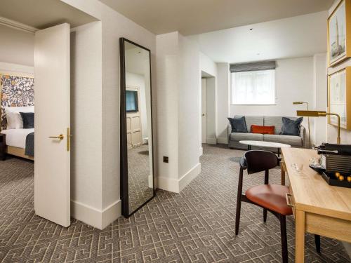 a hotel room with a mirror and a living room at The Municipal Hotel Liverpool - MGallery in Liverpool