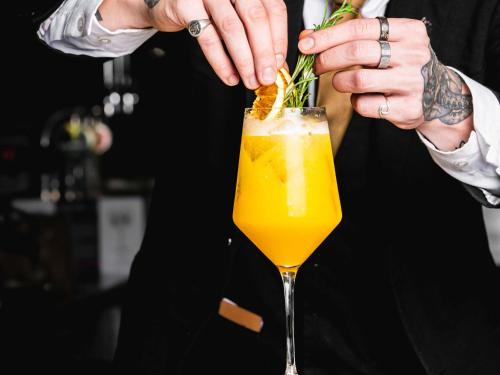 a bartender preparing a drink in a cocktail glass at The Municipal Hotel Liverpool - MGallery in Liverpool