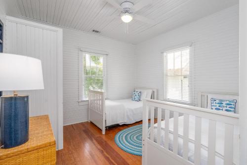 a white room with a crib and a window at Shirley Road Cottage by Tybee Cottages in Tybee Island