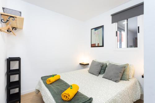 Un dormitorio con una cama con dos objetos amarillos. en Apartamento Retama Laguna Centro, en La Laguna