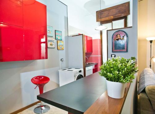a kitchen with a black table and red cabinets at Bilocale Nova Milanese vicino Milano Monza - Parcheggio, terrazzo, Wifi, AC, Netfilx - in Nova Milanese