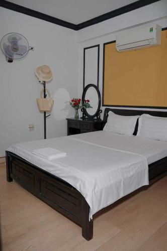 a bedroom with a large bed with white sheets at Phố Xưa Central Hotel Hoa Lư - Ninh Bình in Ninh Binh