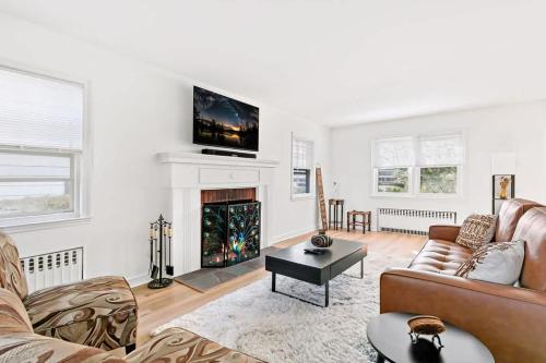 a living room with a couch and a fireplace at Fire pit ~ Game Room ~ near NYC ~ Modern Luxury in New Rochelle