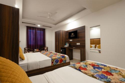 a hotel room with two beds and a mirror at Hotel Grand TELA plaza Near IGI Airport Delhi in New Delhi