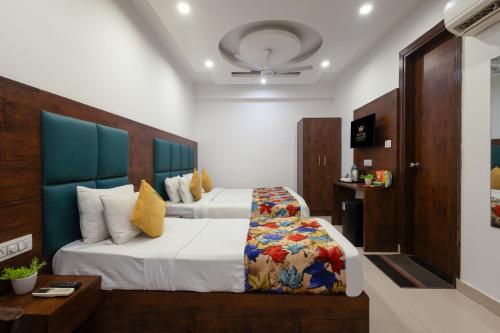 a hotel room with two beds and a table at Hotel Grand TELA plaza Near IGI Airport Delhi in New Delhi
