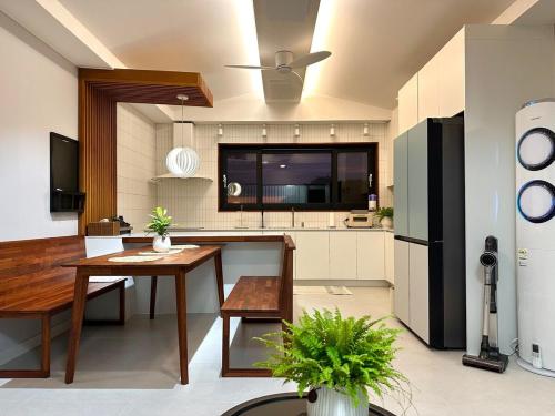 a kitchen with a table and a refrigerator at Dal Dam, a pet-friendly accommodation in the west of Jeju, a private underground bunker event room for family groups in Ŭmbu-dong