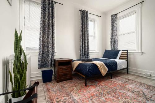 a bedroom with a bed and two windows at Whole House Near NYC and Transit with Game Room Fire Pit and King Bed in New Rochelle