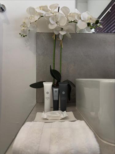 a bathroom counter with a vase of flowers and towels at 105 Clarens Golf Villa in Clarens