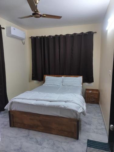 a bedroom with a bed with a black curtain at Vrindavan Homestay Panaji in Batim