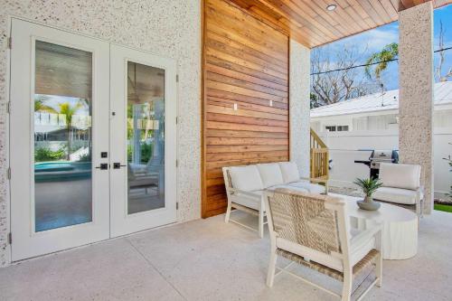 a patio with a table and chairs and sliding glass doors at Between the Waves - Siesta Key Luxury Home in Bailey Hall