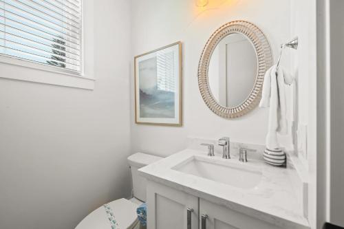a white bathroom with a sink and a mirror at Beach View Paradise - New Anna Maria Island Home in Ilexhurst