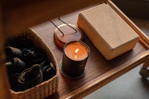 a candle and a box on a wooden table at Pezula Nature Retreat in Knysna