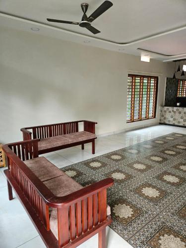 a living room with two benches and a rug at Aadhya Serenity Homestay in Honāvar
