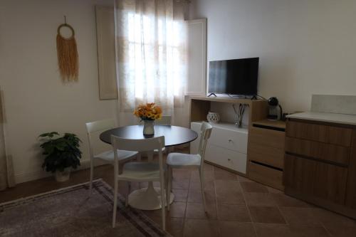 a small kitchen with a table and a tv at Podere La Saliciaia in Monsummano