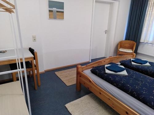 a bedroom with a bed and a desk and a table at Zimmer 7 in Gomadingen
