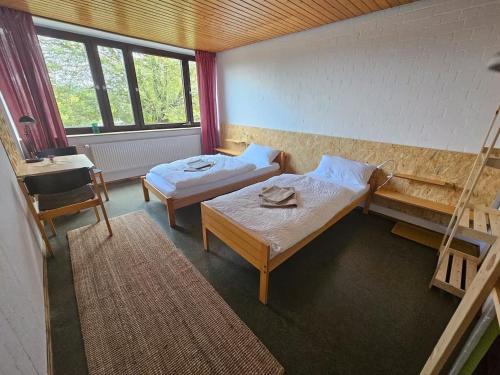 a small room with two beds and a desk at Zimmer 4 in Gomadingen