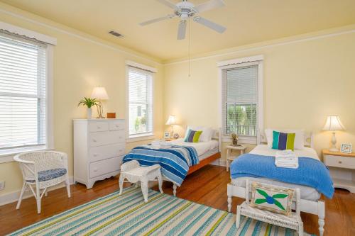 two beds in a room with two windows at Paradise Palms by Tybee Cottages in Tybee Island