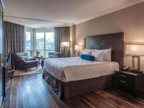 a hotel room with a large bed and a chair at Rimrock Banff, Emblems Collection in Banff