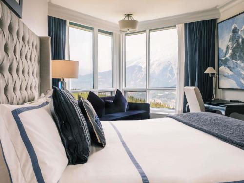 a hotel room with a bed and a large window at Rimrock Banff, Emblems Collection in Banff