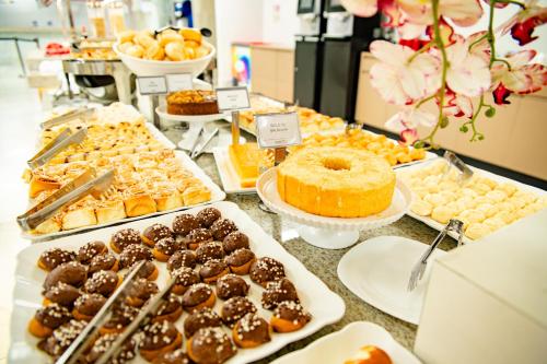 a buffet filled with different types of pastries and desserts at diRoma Spazzio direto com o Grupo diRoma com acesso ao Acqua Park e Café da manhã in Caldas Novas