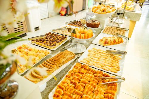 a buffet filled with different types of pastries and desserts at diRoma Spazzio direto com o Grupo diRoma com acesso ao Acqua Park e Café da manhã in Caldas Novas