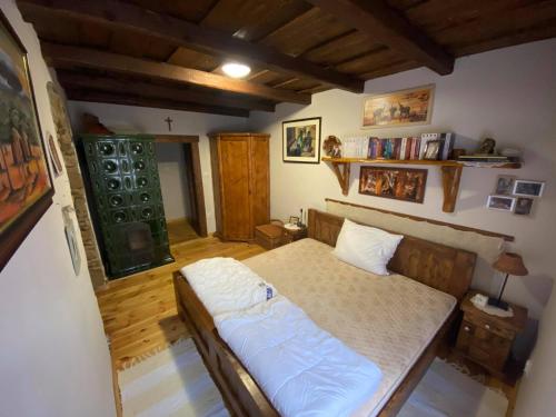 a bedroom with a bed in a room with wooden floors at Bauer Vendégház Püspökszentlászló in Hosszúhétény