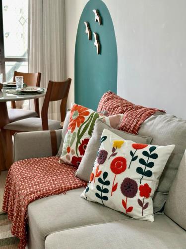 a living room with a couch with pillows at M901 Vista Mar Ar Cond Garagem in Vila Velha