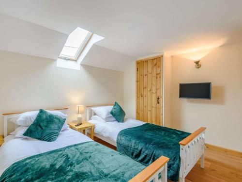 Llanbadarn-fynyddにある4 Bed in Llandrindod Wells 86118のベッドが2つと壁にテレビがある寝室