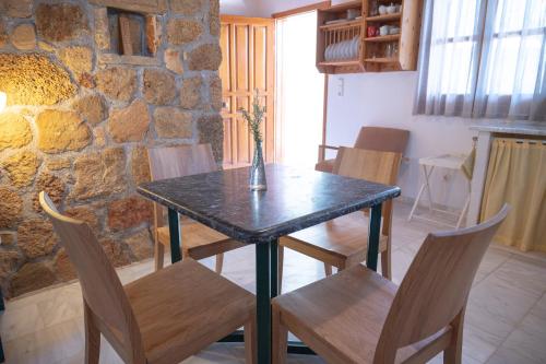 a table and chairs in a room with a stone wall at Terra Ionian in Áyios Ilías