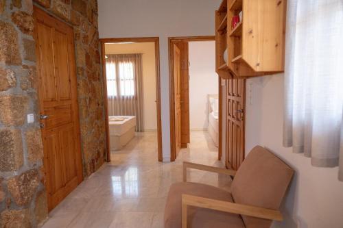 a living room with a chair and a bathroom at Terra Ionian in Áyios Ilías