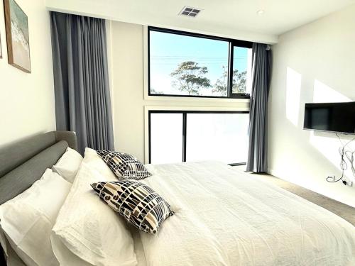 a bedroom with a bed with two pillows and a window at Williamstown Village in Williamstown