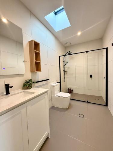 a white bathroom with a toilet and a shower at Williamstown Village in Williamstown