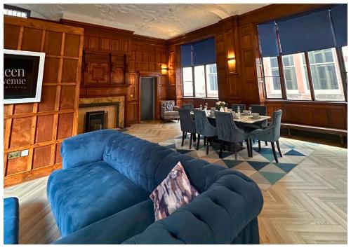 a living room with a blue couch and a table at 16 Queen Avenue Collection by Happy Days in Liverpool