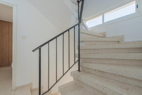 a staircase in a house with white walls and a window at TelMar duplex in Livadhia
