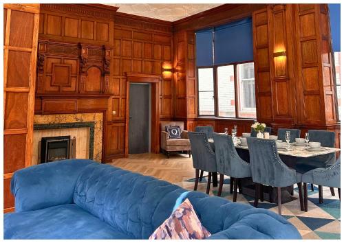 a living room with a blue couch and a table at 16 Queen Avenue Collection by Happy Days in Liverpool