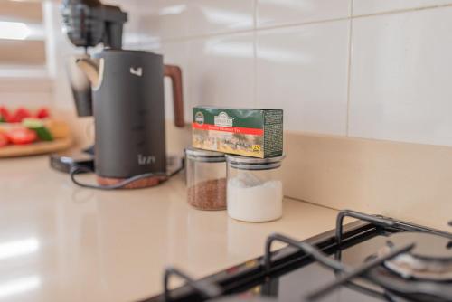 a counter top with a coffee maker and some spices at TelMar duplex in Livadhia