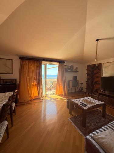 a living room with a table and a large window at MILA Adriatic sea view apartment, Sveti Stefan in Sveti Stefan