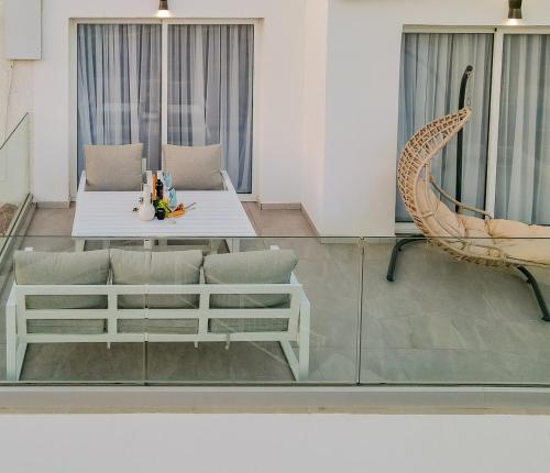 un salon avec une table en verre et des chaises dans l'établissement TelMar SeaView, à Oroklini